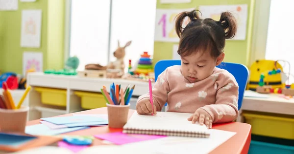 Очаровательная Китаянка Дошкольница Сидит Столом Рисует Блокноте Детском Саду — стоковое фото