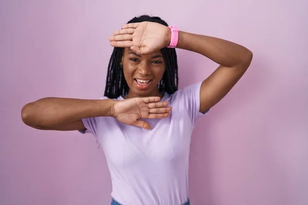 Африканская Американка Косичками Стоящая Розовом Фоне Весело Улыбающаяся Играющая Смотрит — стоковое фото