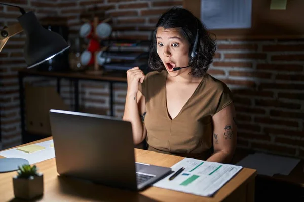 Young Hispanic Woman Working Office Night Surprised Pointing Hand Finger —  Fotos de Stock