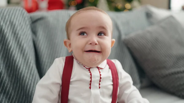 Adorable Hispanic Baby Sitting Sofa Christmas Tree Crying Home — Stockfoto