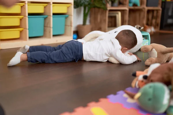可爱的幼儿在家里玩洋娃娃躺在地板上 — 图库照片