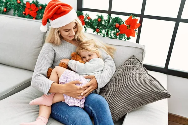 母亲和女儿坐在家里的圣诞装饰品旁拥抱在一起 — 图库照片