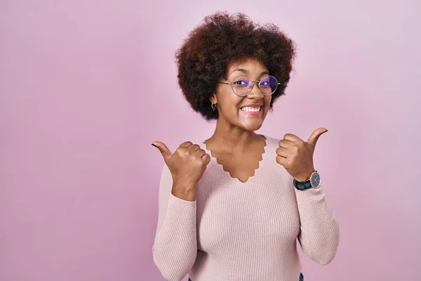 年轻的非洲裔美国女人站在粉红的背景下 成功地做着积极的手势 微笑着竖起大拇指 快乐地 快乐的表达和胜利的姿态 — 图库照片