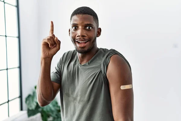 Молодой Африканский Американец Получающий Вакцину Показывает Руку Помощью Пластыря Удивленный — стоковое фото