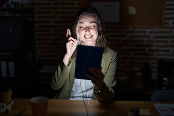 Blonde Caucasian Woman Working Office Night Gesturing Finger Crossed Smiling — Stock Photo, Image