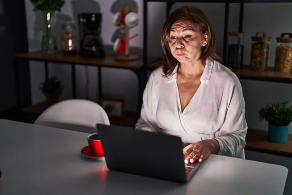 Latynoska Kobieta Średnim Wieku Używająca Laptopa Domu Nocy Nadyma Policzki — Zdjęcie stockowe