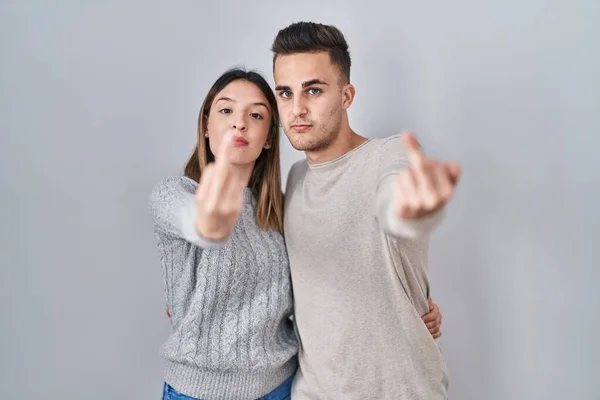 Young Hispanic Couple Standing White Background Showing Middle Finger Impolite — Stockfoto