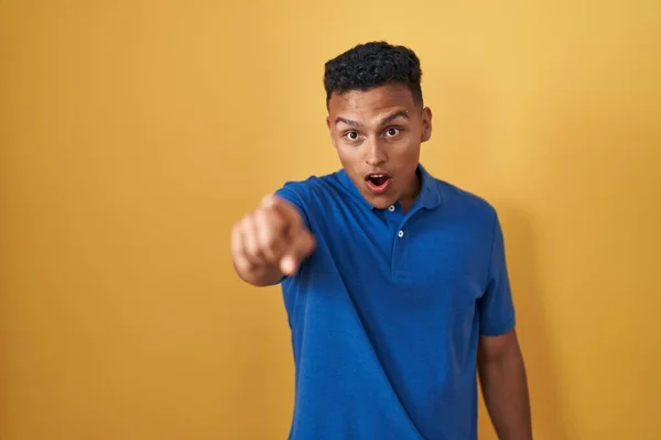 Young Hispanic Man Standing Yellow Background Pointing Finger Surprised Ahead — Stock Photo, Image