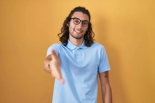 Young Hispanic Man Standing Yellow Background Smiling Friendly Offering Handshake — Stock Photo, Image