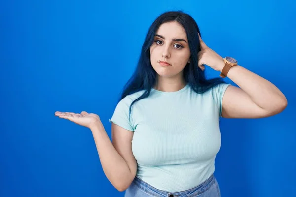 Jong Modern Meisje Met Blauw Haar Staande Blauwe Achtergrond Verward — Stockfoto