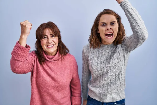 Mother Daughter Standing Blue Background Angry Mad Raising Fist Frustrated — Stockfoto