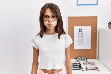 Gözlüklü, komik yüzlü, yanak şişiren genç İspanyol kız. Havayla şişmiş ağız, çılgın bir ifade.. 