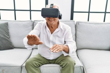 Son sınıf öğrencisi evde sanal gerçeklik gözlüğü kullanarak video oyunu oynuyor.