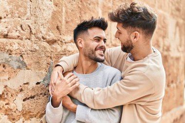 Young couple smiling confident hugging each other at street