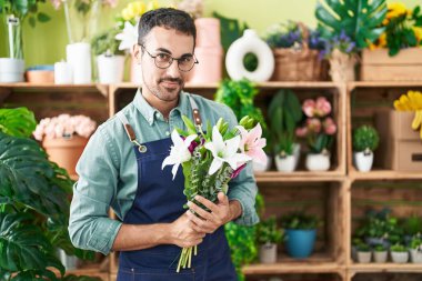 Çiçekçide elinde bir buket çiçek tutan İspanyol bir çiçekçi.