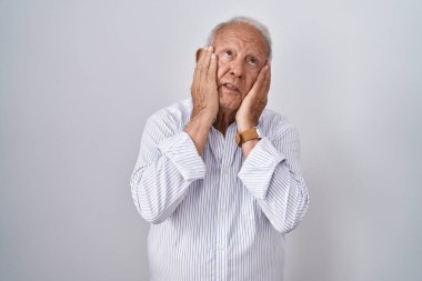 Gri saçlı yaşlı adam arka planda duruyor. Yorgun eller yüzünü, depresyonunu ve üzüntüsünü kapatıyor. Sorunları yüzünden üzgün ve sinirli. 