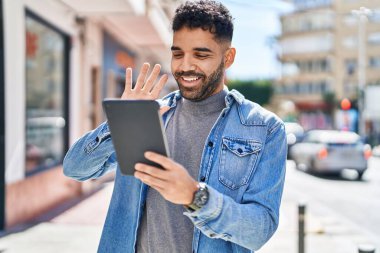 Latin asıllı genç adam gülümsüyor.