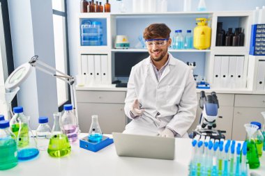 Young arab man scientist having video call working at laboratory