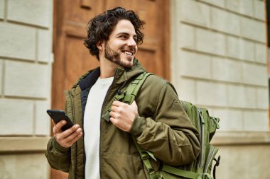 Şehirde akıllı telefon kullanan yakışıklı bir İspanyol.