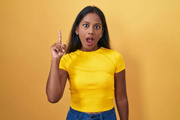 Young Indian Woman Standing Yellow Background Pointing Finger Successful Idea — Zdjęcie stockowe