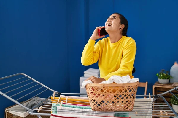 Young Hispanic Woman Hanging Clothes Clothesline Talking Smartphone Laundry Room — Fotografia de Stock