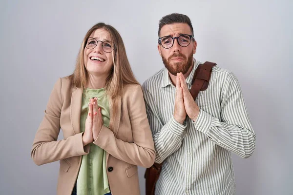 Young Couple Standing White Background Begging Praying Hands Together Hope — Stock Photo, Image