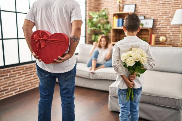 Family surprise mother with gift and flowers on back at home