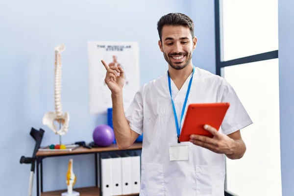 Young Hispanic Physiotherapist Man Doing Online Appointment Smiling Happy Pointing — Stockfoto