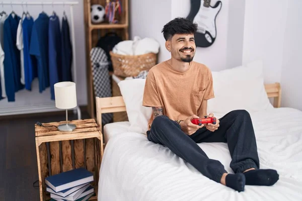 Young Hispanic Man Playing Video Game Sitting Bed Bedroom — Foto Stock