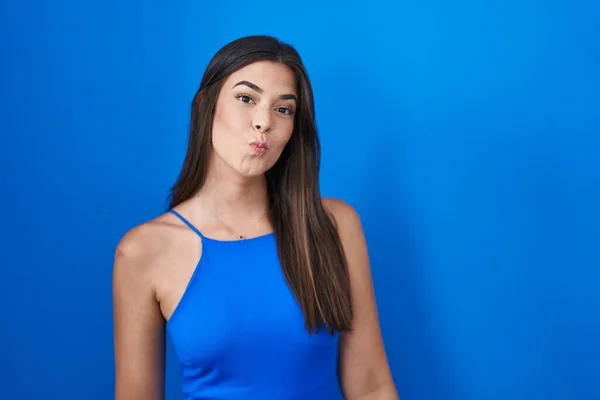 Mulher Hispânica Sobre Fundo Azul Olhando Para Câmera Soprando Beijo — Fotografia de Stock