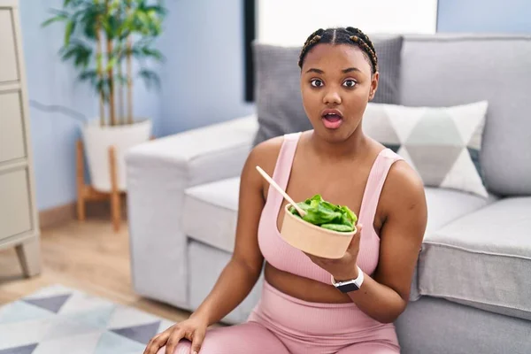 African American Woman Braids Eating Salad Working Out Home Scared — Stockfoto