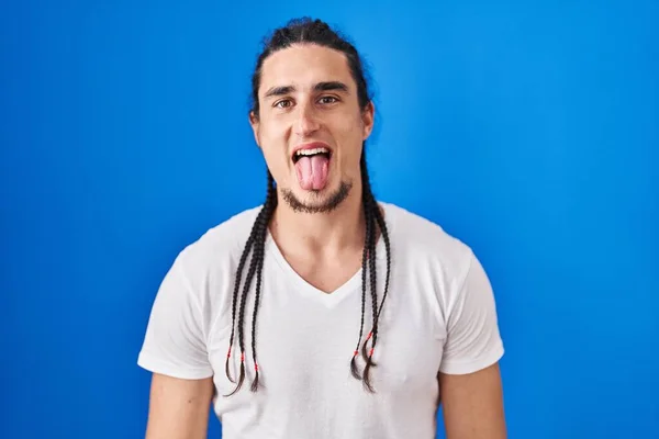 Hispanic Man Long Hair Standing Blue Background Sticking Tongue Out — Stockfoto