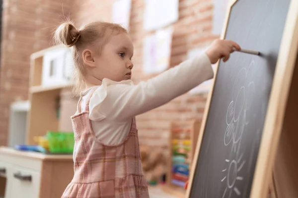 可敬的高加索女孩 站在幼儿园的黑板上画画 — 图库照片