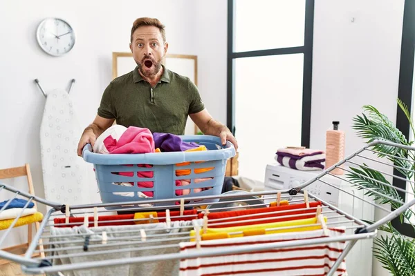 Middle Age Man Doing Laundry Holding Basket Afraid Shocked Surprise — Stockfoto