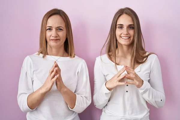 Middle Age Mother Young Daughter Standing Pink Background Hands Together — Stock Photo, Image