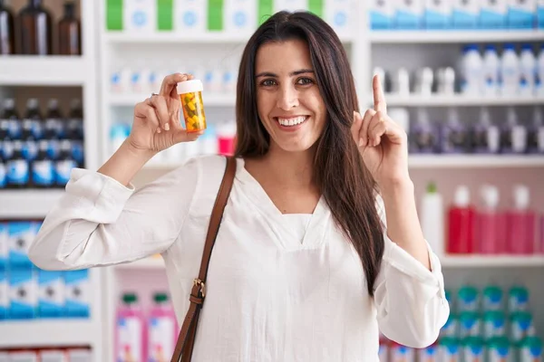Young Brunette Woman Shopping Pharmacy Drugstore Holding Pills Surprised Idea — Zdjęcie stockowe