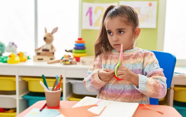 Adorable Hispanic Girl Student Sitting Table Cutting Paper Kindergarten — Foto de Stock
