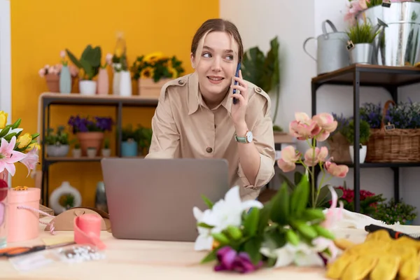 Young Caucasian Woman Florist Talking Smartphone Using Laptop Flower Shop — Stockfoto