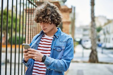 Genç İspanyol adam şehirde akıllı telefon kullanıyor.