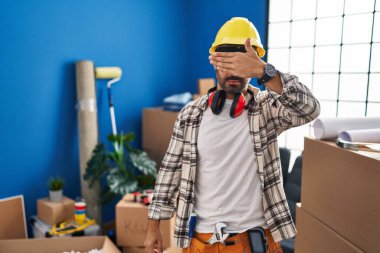 Sakallı, evde çalışan, gözlerini kapayan, ciddi ve üzgün görünen İspanyol bir adam. Görme, saklama ve reddetme konsepti 