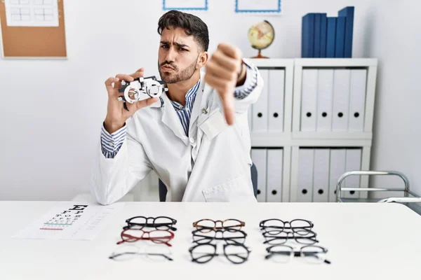 Young Optician Man Holding Optometry Glasses Looking Unhappy Angry Showing — Fotografia de Stock