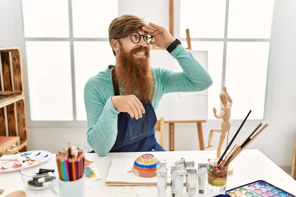 アートスタジオで長いひげの絵粘土ボウルと赤毛の男は非常に幸せと遠くに手を頭の上に見て笑顔 検索の概念 — ストック写真
