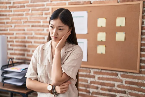 Chinese young woman working at the office doing presentation thinking looking tired and bored with depression problems with crossed arms.