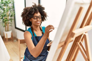 Genç Afrikalı Amerikalı kadın sanat stüdyosunda kendine güvenen bir çizim yapıyor.
