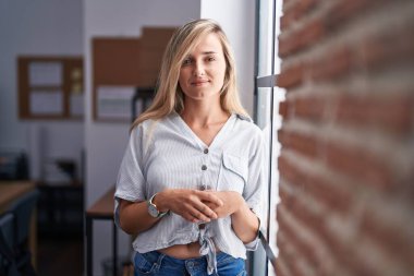 Ofiste kendine güvenen genç sarışın iş kadını gülümsemesi.