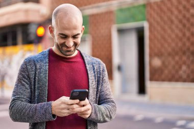 Sokakta akıllı telefon kullanan kendine güvenen genç adam.