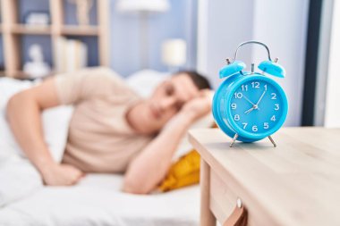 Sokakta ciddi bir ifadeyle yatan Latin asıllı genç adam.