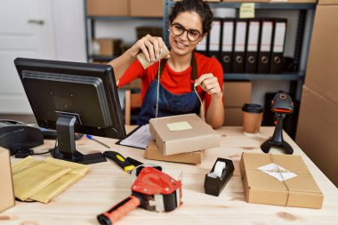 Genç Latin kadın dış ticaret işçisi ofiste paket siparişi hazırla.