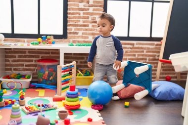 Anaokulunda yüzünde ciddi bir ifadeyle duran sevimli İspanyol çocuk.