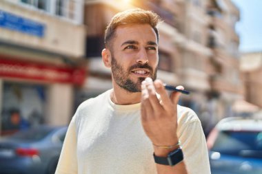 Genç İspanyol adam gülümsüyor. Kendine güveniyor. Sokakta akıllı telefondan konuşuyor.